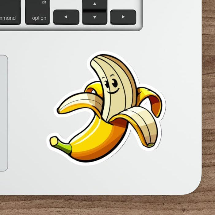 A sticker depicting a cartoon banana with a smiling face placed on a laptop.