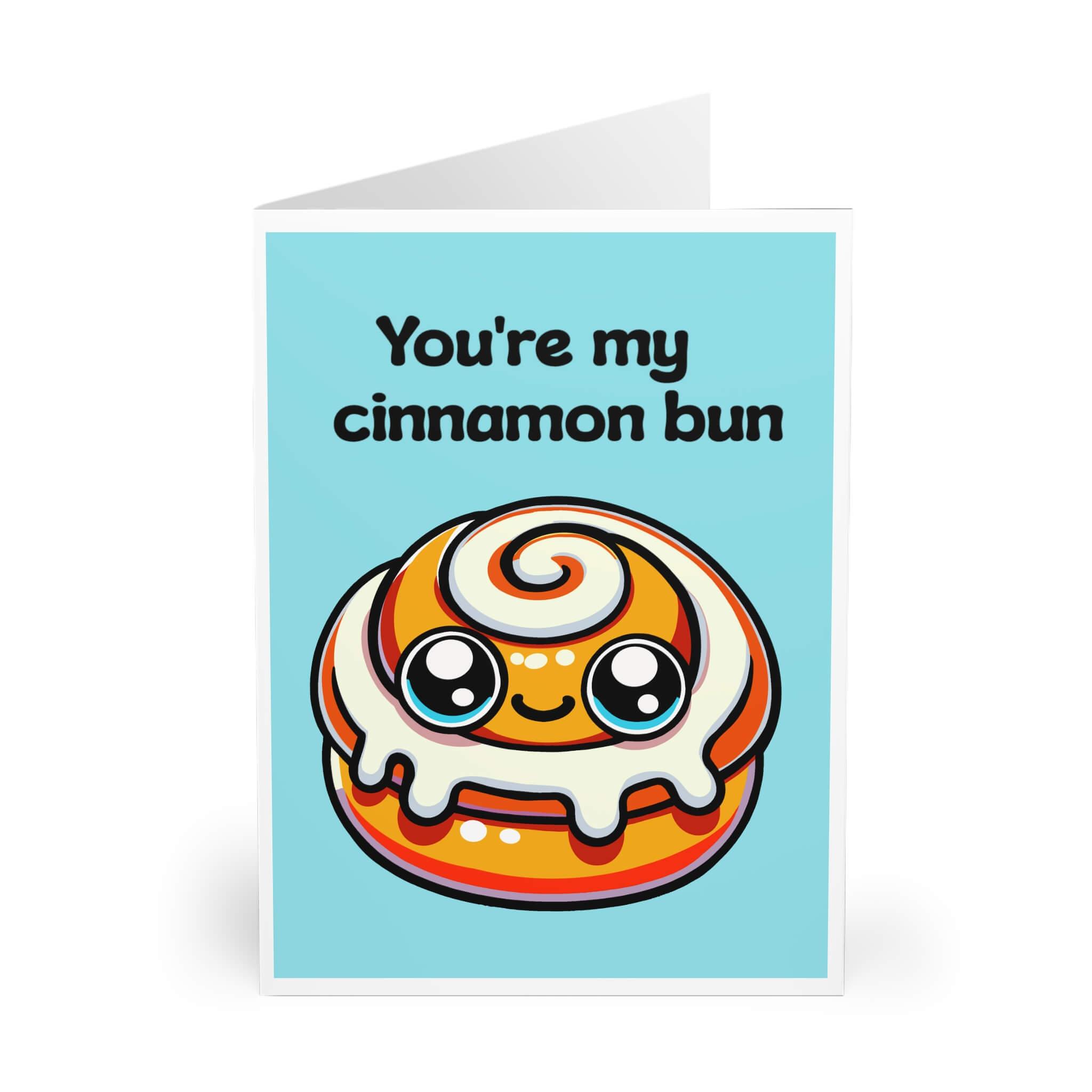 A greeting card with a colorful illustration of a smiling cinnamon bun with the text 'You're my cinnamon bun' written on it.
