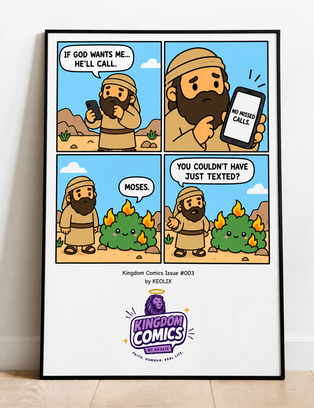 A framed four-panel comic print leaning against a wall on a light wood floor. The comic, titled 'Kingdom Comics Issue 003 by KEOLIX', shows a cartoon bearded man in a desert setting making phone calls and texting, with humorous captions.