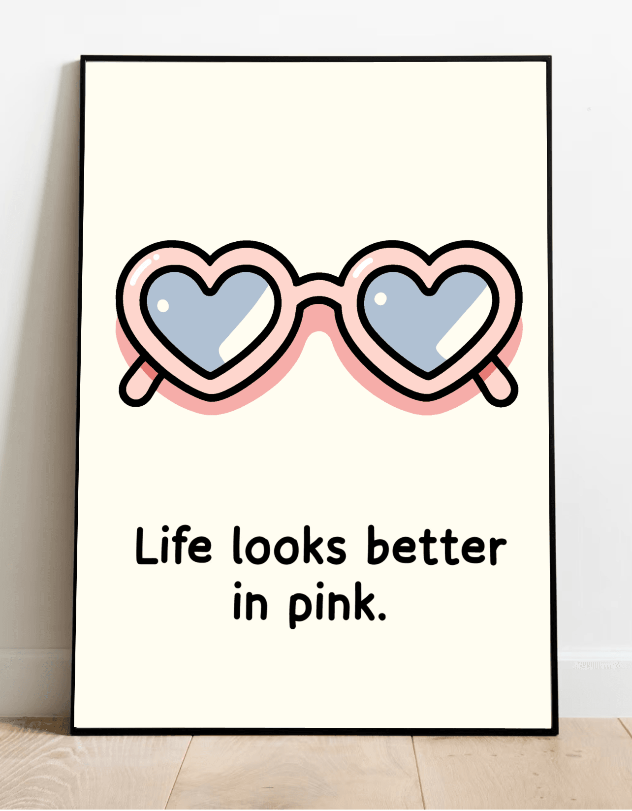 Introducing the "Life Looks Better in Pink Print"! This delightful illustration showcases heart-shaped sunglasses with adorable pink frames and cool, reflective blue lenses, capturing a whimsical sense of positivity. Beneath the charming artwork, bold black lettering proclaims, "Life looks better in pink." Perfectly placed on a light wooden floor against a crisp white wall, this eye-catching pink art print is sure to add a splash of joy to any space!