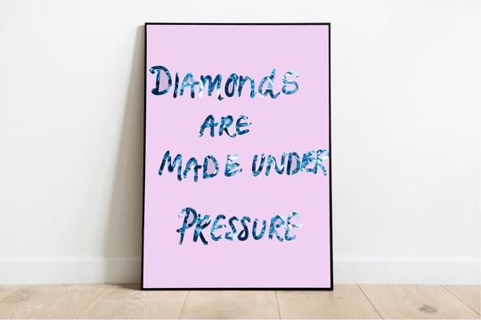 Introducing the "Diamonds Under Pressure Artwork" framed poster—a true gem for your space! This striking piece features the empowering phrase in a textured blue font, exuding boldness and strength. Set against a soft pink background, its vibrant colors really pop, making it a perfect fit for any white wall. With its elegant presence on a light wooden floor, this artwork promises to be an inspiring addition to your home or office decor.