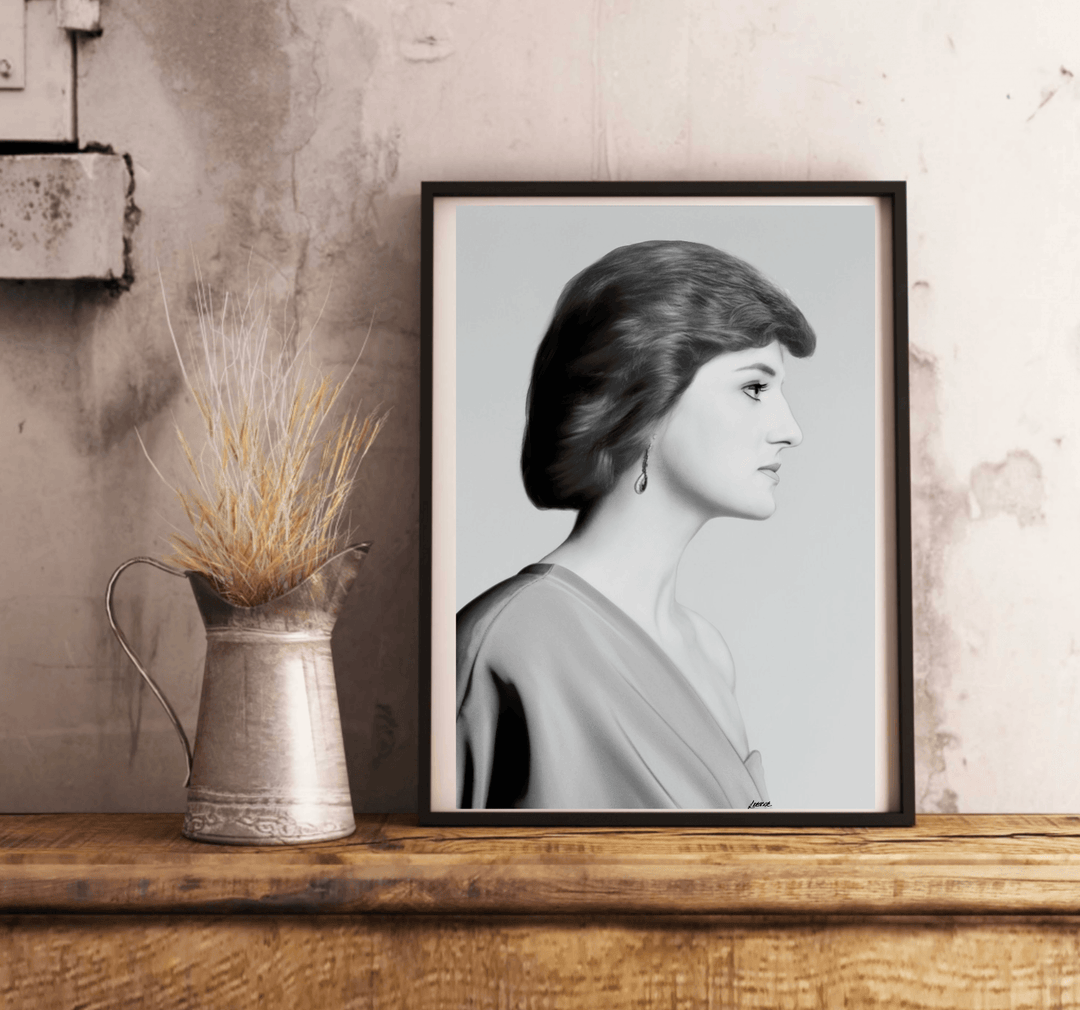 Introducing "Eternal Grace - Handcrafted Princess Diana Print," a stunning black and white framed portrait that radiates timeless elegance. This captivating piece showcases a woman in profile, set beautifully on a wooden floor against a pristine white wall. With short, wavy locks and an elegant off-the-shoulder dress reminiscent of Princess Diana's iconic style, this print truly embodies the essence of royalty. A delicate dangling earring adds just the right touch of grace, making this subtly tilted image p