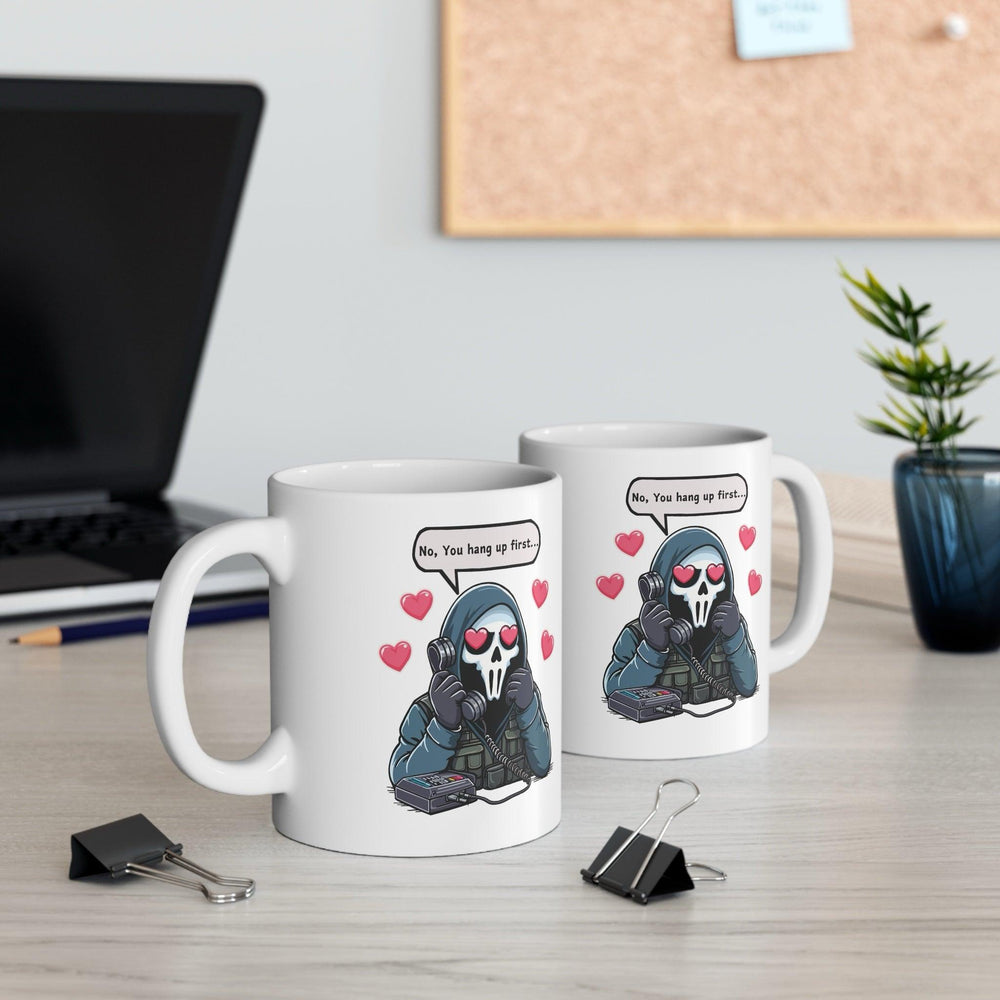 White ceramic mug featuring a cute cartoon couple in a sweet exchange with the phrase 'No, You Hang Up First,' perfect for couples who love playful bante