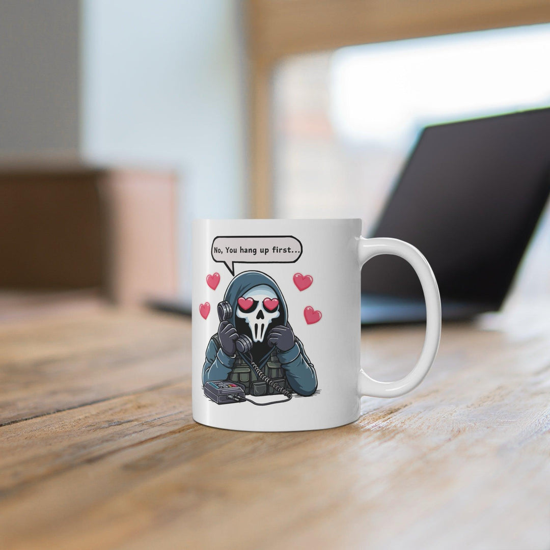 White ceramic mug featuring a cute cartoon couple in a sweet exchange with the phrase 'No, You Hang Up First,' perfect for couples who love playful bante