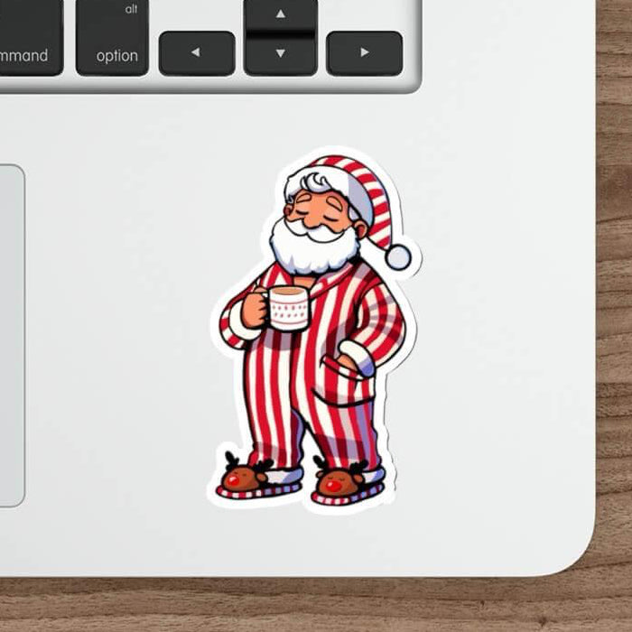 Cozy Santa waterproof sticker featuring Santa in red-striped pajamas holding a hot drink, perfect for decorating laptops, water bottles, and journals with festive holiday cheer.