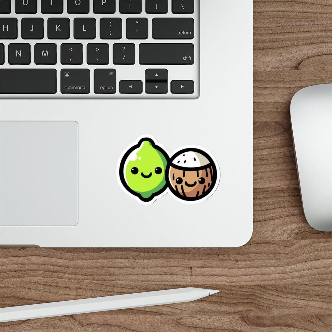 A sticker with a cartoon lime and coconut design placed on a laptop.