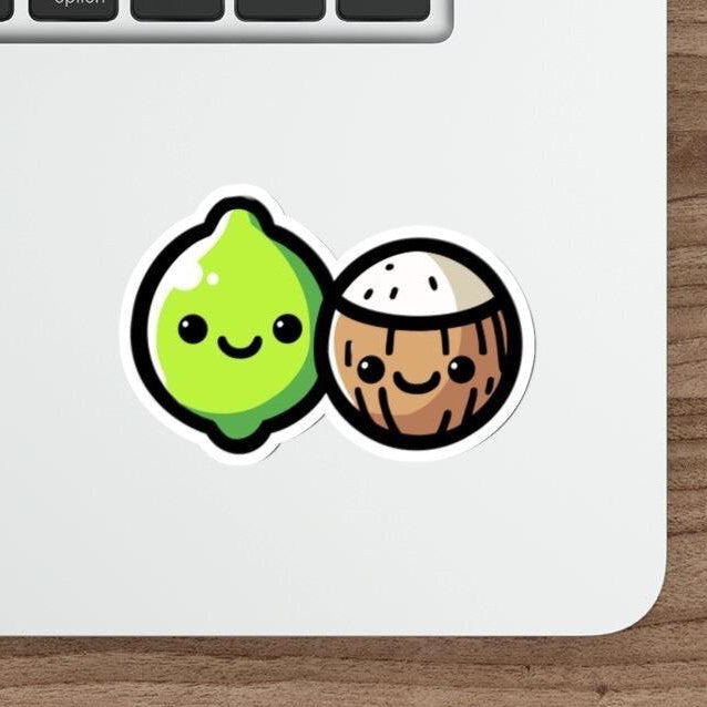 A sticker with a cartoon lime and coconut design placed on a laptop.