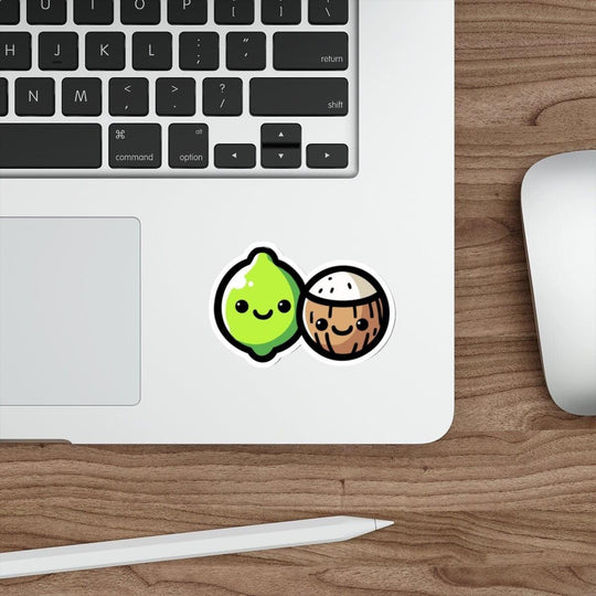 A sticker with a cartoon lime and coconut design placed on a laptop.