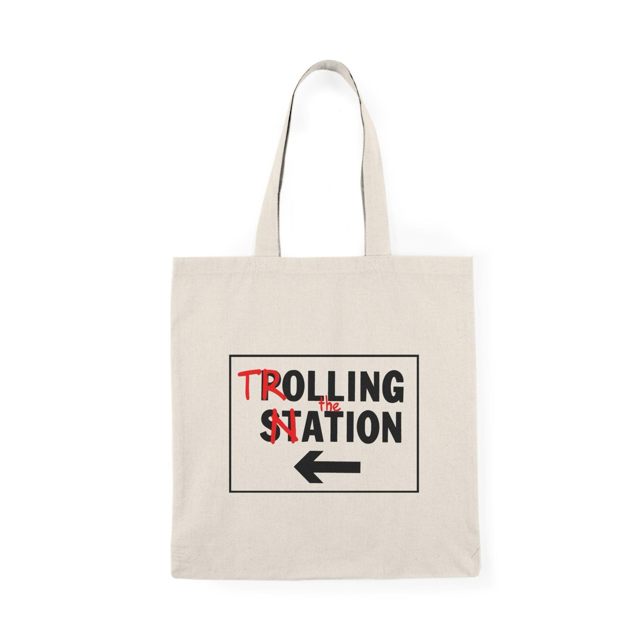 A natural tote bag featuring a graphic with the text 'Trolling the Nation' alongside an arrow. This playful design captures a cheeky sense of humor, making it a fun accessory for those who enjoy light-hearted banter