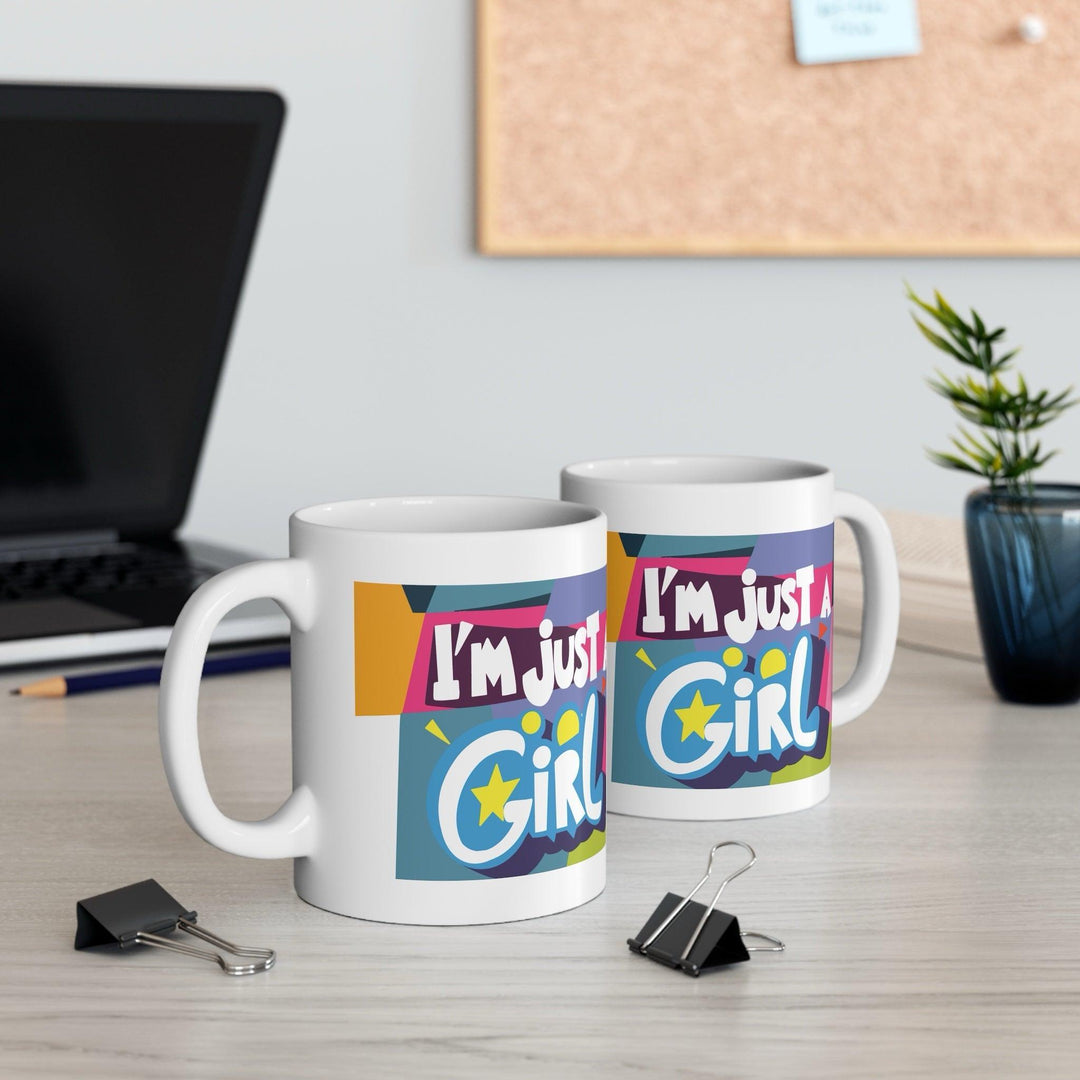 Colorful white ceramic mug with the bold and empowering text 'I'm Just a Girl,' perfect for showing off girl power in a stylish way