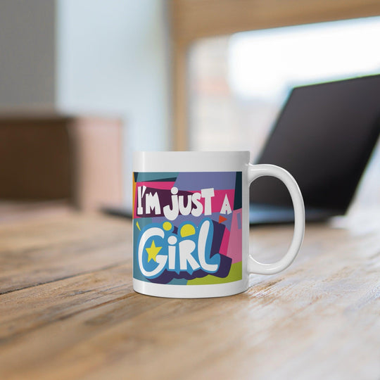 Colorful white ceramic mug with the bold and empowering text 'I'm Just a Girl,' perfect for showing off girl power in a stylish way