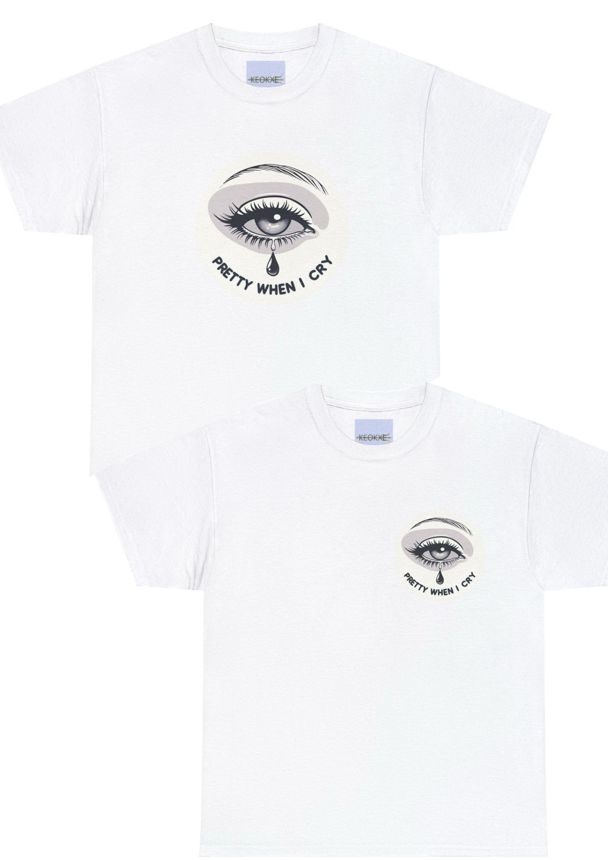 White T-shirt featuring a small, subtle illustration of a single eye with teardrops, along with the phrase 'Pretty When I Cry.' A delicate and emotional design, perfect for expressing vulnerability with a hint of irony.