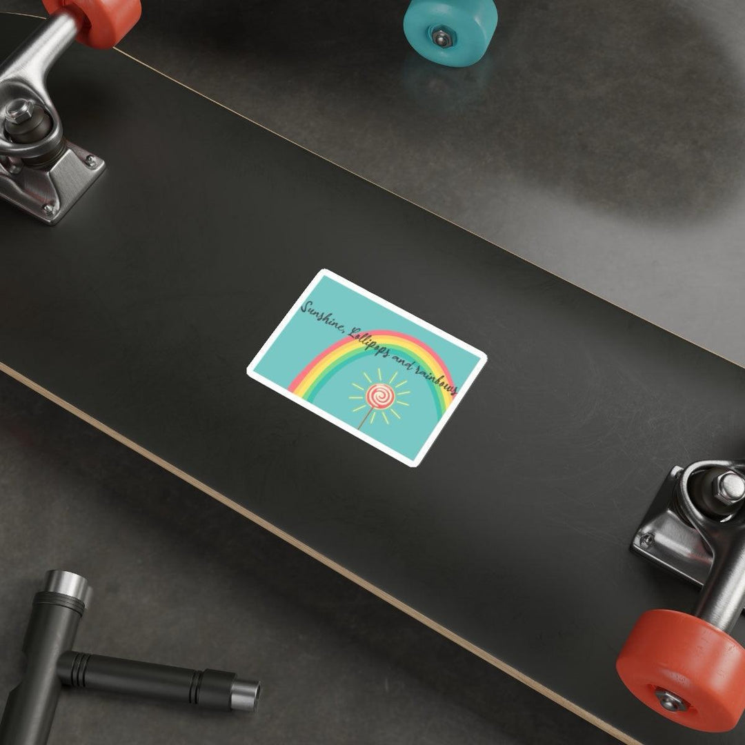 Sunshine, Lollipops, and Rainbows Waterproof Sticker: A circular sticker featuring a bright rainbow with a shining sun, capturing a happy, playful aesthetic. Ideal for personalizing laptops, water bottles, and more. KEOLIX
