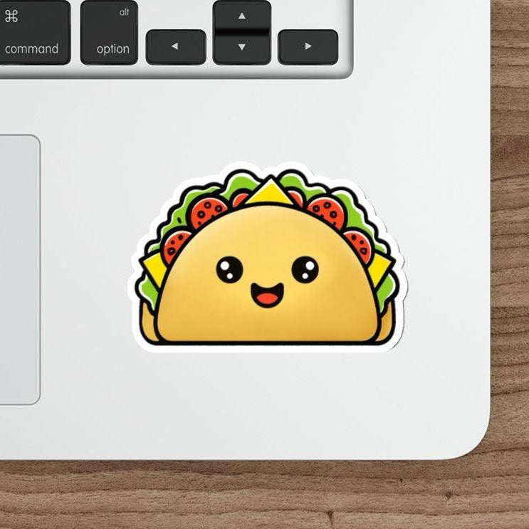 A sticker depicting a cute, smiling taco with lettuce and tomato toppings placed on a laptop.
