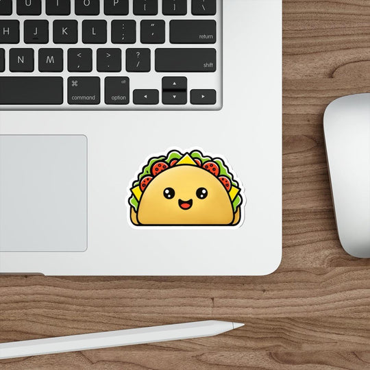 A sticker depicting a cute, smiling taco with lettuce and tomato toppings placed on a laptop.