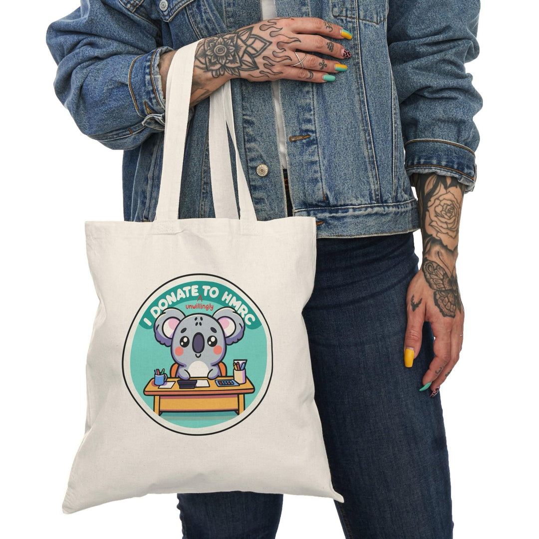 Tote bag featuring a witty design with the phrase 'I Donate Unwillingly to HMRC' in bold typography. The playful and humorous graphics capture a lighthearted take on taxes, making it a fun accessory for those who appreciate cheeky statements while carrying their everyday essentials.