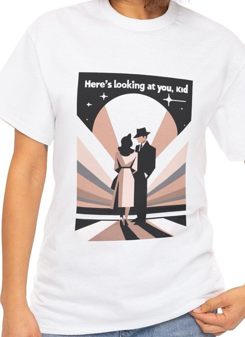 White T-shirt showcasing a stylized black-and-white illustration of a famous film scene with the phrase 'Here's to Looking at You, Kid.' A nostalgic design for movie lovers, evoking timeless Hollywood moments
