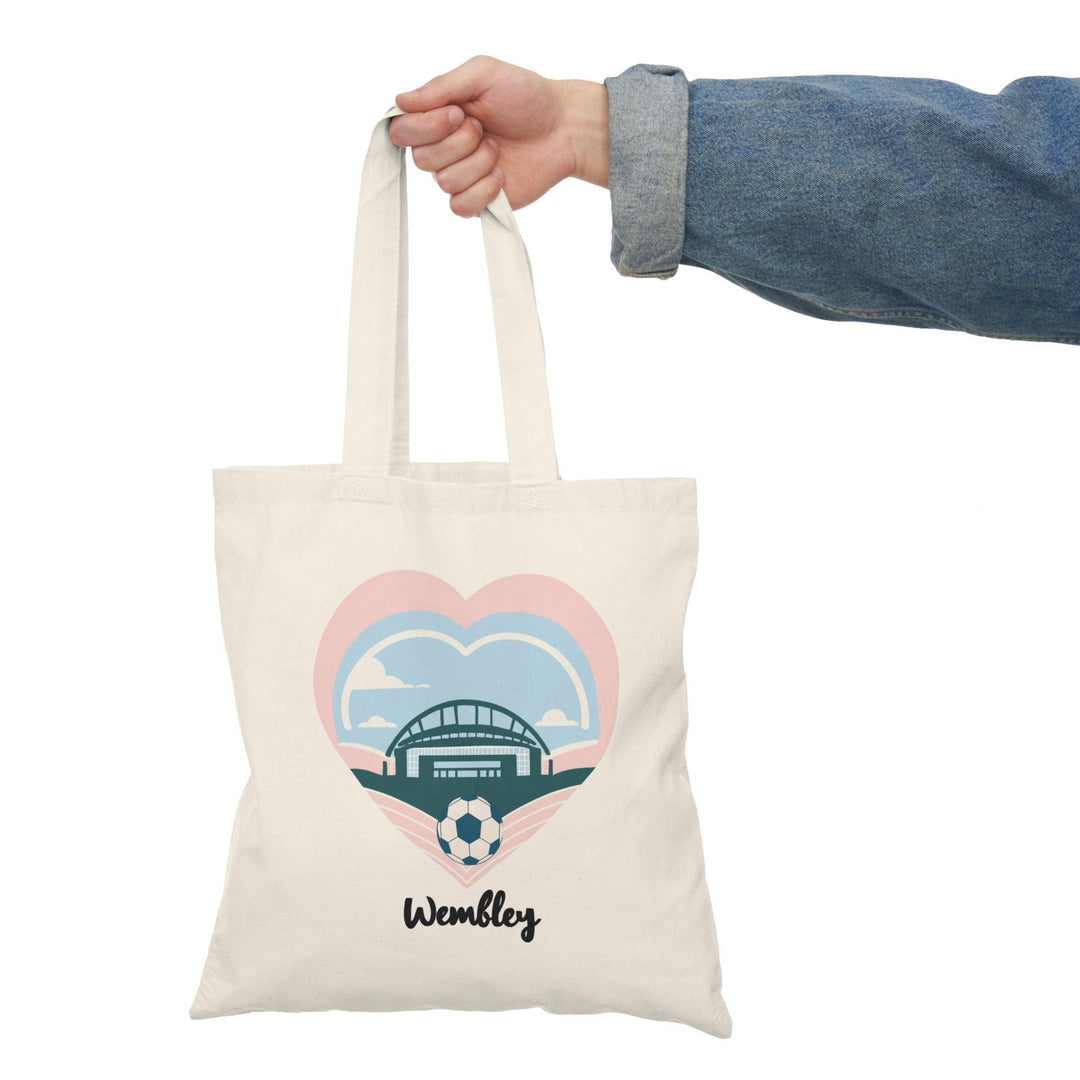 A natural tote bag featuring a graphic illustration of the iconic Wembley Stadium, surrounded by heart motifs. This design celebrates the spirit of the venue, making it a perfect accessory for sports fans and music lovers alike