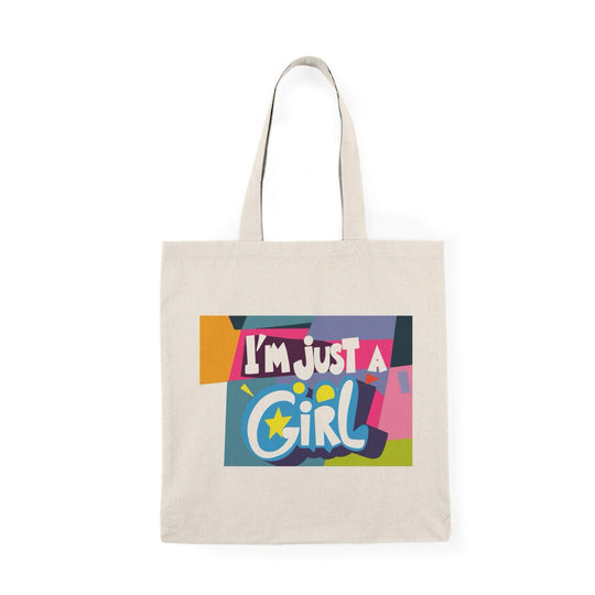 A cream-colored tote bag featuring a vibrant, multicolored text graphic that reads 'I’m Just a Girl.' The bright colors and playful font reflect a fun and youthful spirit, making it an excellent choice for everyday use