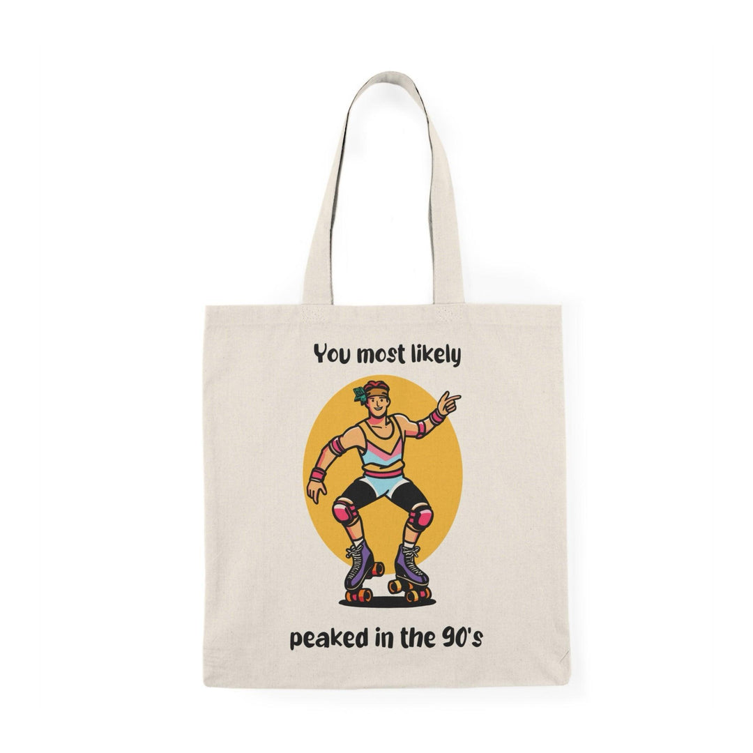 A cream tote bag showcasing a colorful graphic of a character with the text 'You Most Likely Peaked in the 90's.' The nostalgic design resonates with those who appreciate the fun and style of the 90s, adding a playful touch to any outfit.