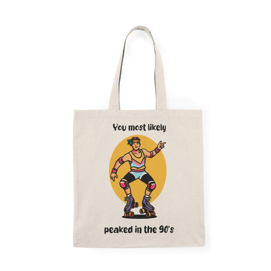 A cream tote bag showcasing a colorful graphic of a character with the text 'You Most Likely Peaked in the 90's.' The nostalgic design resonates with those who appreciate the fun and style of the 90s, adding a playful touch to any outfit.
