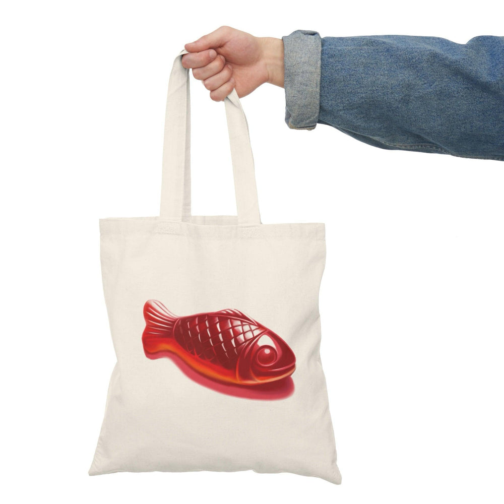 Eco-friendly canvas tote bag featuring a bright red Swedish Fish candy illustration. Perfect for grocery runs, casual outings, or as a fun gift for candy lovers - Baby Keo.