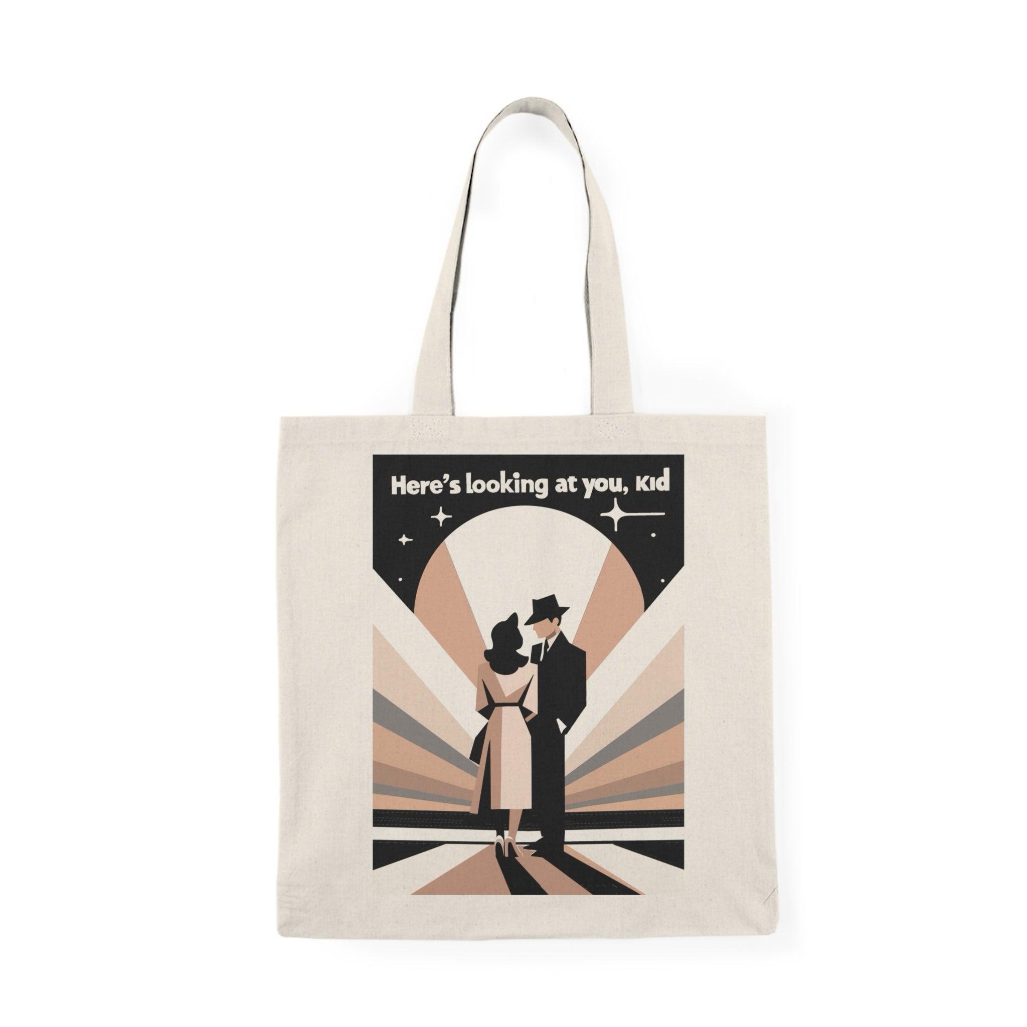 Stylish canvas tote bag featuring a vintage-inspired design with a figure in a suit and the quote 'Here’s Looking at You Kid' in black and white. A perfect tote for movie lovers or vintage enthusiasts - Baby Keo
