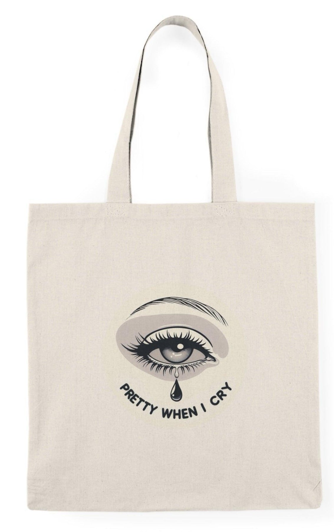 A natural canvas tote bag showcasing an artistic graphic of a teardrop with the phrase 'Pretty When I Cry.' The thoughtful design combines emotion with beauty, appealing to those who embrace vulnerability and self-expression  KEOLIX