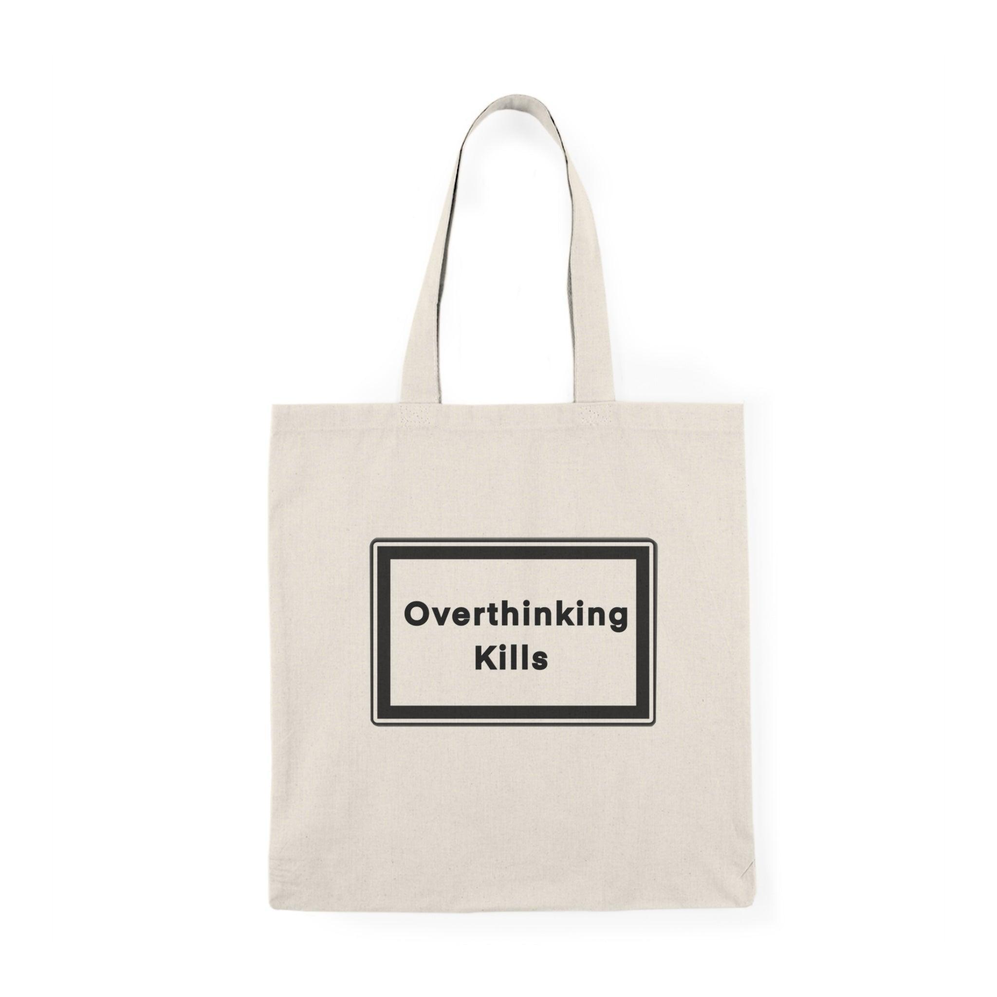 A natural canvas tote bag with a bold and straightforward message: 'Overthinking kills' displayed prominently in a black rectangular box. The minimalist design effectively conveys a powerful reminder about the effects of excessive thought and stress.