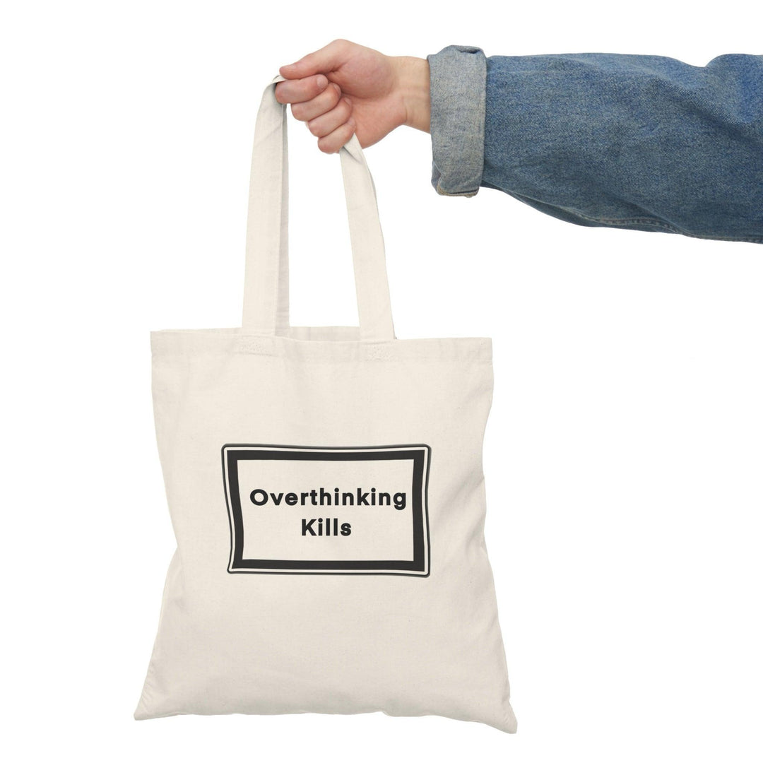 A natural canvas tote bag with a bold and straightforward message: 'Overthinking kills' displayed prominently in a black rectangular box. The minimalist design effectively conveys a powerful reminder about the effects of excessive thought and stress.