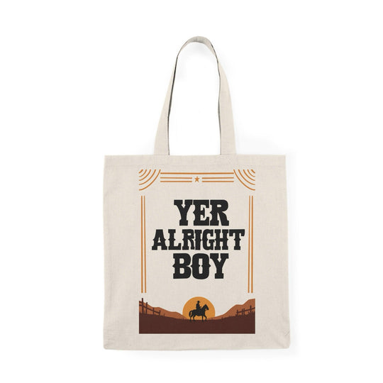A natural tote bag with bold typography stating 'Yer Alright Boy,' accompanied by a graphic of a landscape. This fun design adds a lighthearted, friendly touch, making it perfect for those with a charming sense of humor