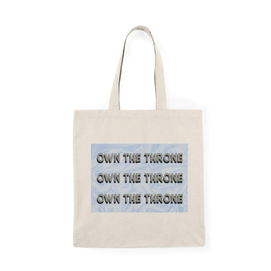 A cream tote bag featuring the phrase 'Own The Throne' repeated in a stylish and colorful font. The vibrant colors and eye-catching design inspire confidence and empowerment, making it a great accessory for those who want to make a statement