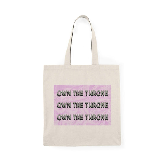 A cream tote bag featuring the phrase 'Own The Throne' repeated in a stylish and colorful font. The vibrant colors and eye-catching design inspire confidence and empowerment, making it a great accessory for those who want to make a statement