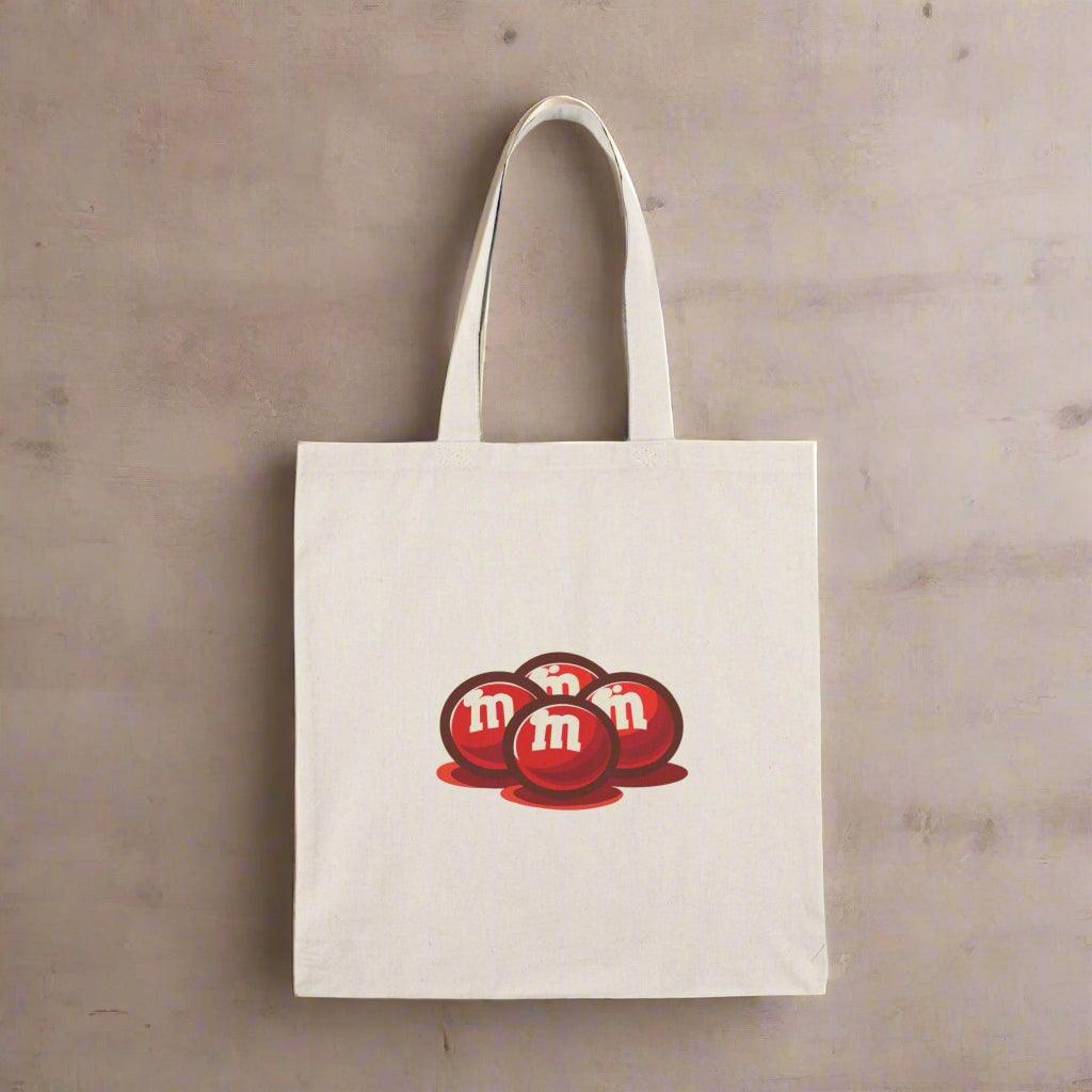 Fun and playful canvas tote bag featuring the classic M&M’s candy logo in bright colors. Perfect for casual outings, shopping trips, or as a gift for candy lovers. Durable and eco-friendly - Baby Keo
