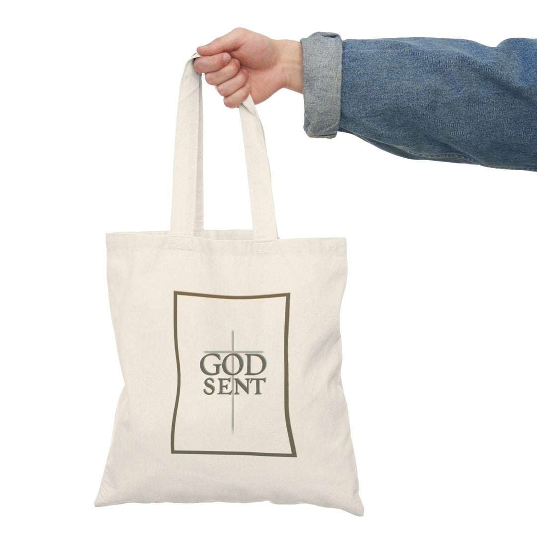 Tote bag featuring a striking design with the word 'Godsent' elegantly displayed, complemented by artistic elements that evoke a sense of faith and inspiration. The bold typography and vibrant colors create a meaningful accessory, perfect for expressing spirituality while adding style to your everyday carry."