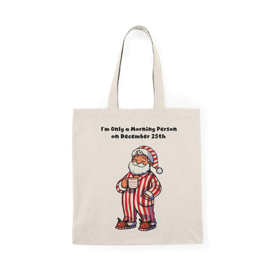 Funny Christmas tote bag with cozy Santa in striped pajamas and the phrase 'I'm Only a Morning Person on December 25th.' Perfect for holiday shopping, made from 100% recycled cotton