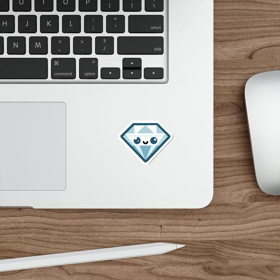 A blue diamond cartoon sticker with a cute face pasted on a laptop next to a computer mouse on a wooden desk.