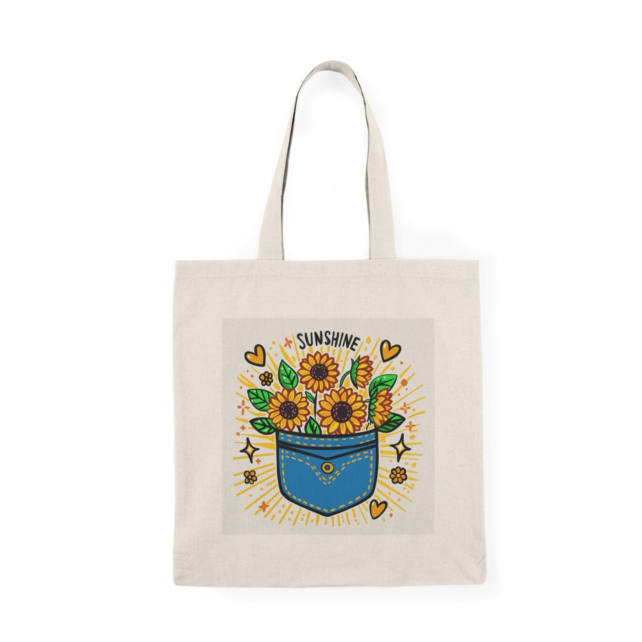 A natural tote bag adorned with a vibrant illustration of a flower pot filled with colorful flowers and the text 'Pocket Full of Sunshine.' The cheerful design radiates positivity and joy, making it a delightful accessory for spring and summer outings.