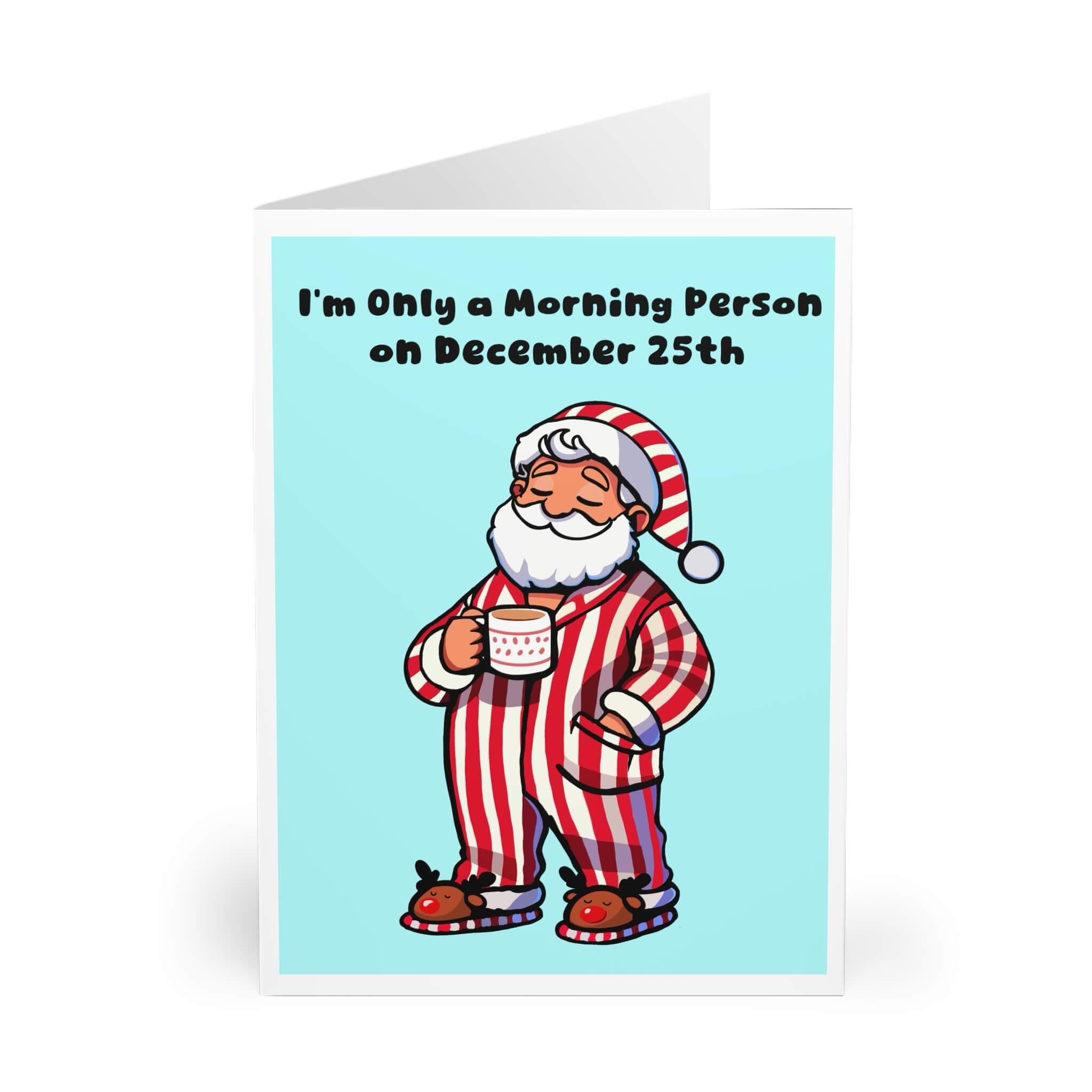 Funny Christmas card featuring Santa in striped pajamas, holding a mug with the phrase 'I'm Only a Morning Person on December 25th.' Perfect for adding humor to holiday greetings. Available in A5, 5x7, and A6 sizes