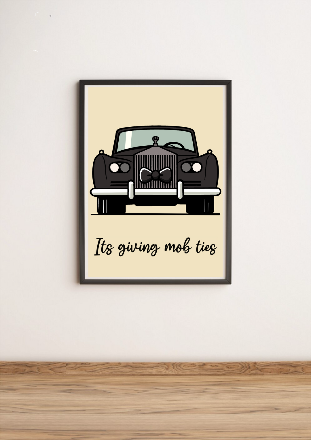 Introducing the charming Mob Ties Print, a delightful piece that's perfect for adding character to your space! This art print rests effortlessly against a crisp white wall, showcased beautifully on a polished wooden floor. Picture an illustrated vintage black car, all dressed up with a snazzy bow tie on its grille, exuding timeless elegance. Below the car, the words "It's giving mob ties" are penned in lovely cursive script, subtly enhancing the light beige backdrop. It's got that classic Rolls Royce vibe w