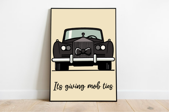 Introducing the charming Mob Ties Print, a delightful piece that's perfect for adding character to your space! This art print rests effortlessly against a crisp white wall, showcased beautifully on a polished wooden floor. Picture an illustrated vintage black car, all dressed up with a snazzy bow tie on its grille, exuding timeless elegance. Below the car, the words "It's giving mob ties" are penned in lovely cursive script, subtly enhancing the light beige backdrop. It's got that classic Rolls Royce vibe w