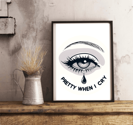 Introducing the "Pretty When I Cry" print—an eye-catching piece of art that brings a pop of emotion to any space! Featuring a beautifully illustrated crying eye with fluttery long lashes and a striking eyebrow, this print stands out against its backdrop. The phrase "Pretty When I Cry" is artfully displayed in bold, curved letters beneath the teardrop, adding an extra layer of charm. Whether leaning against a white wall or resting on light wooden flooring, this framed artwork is sure to elevate your decor. W