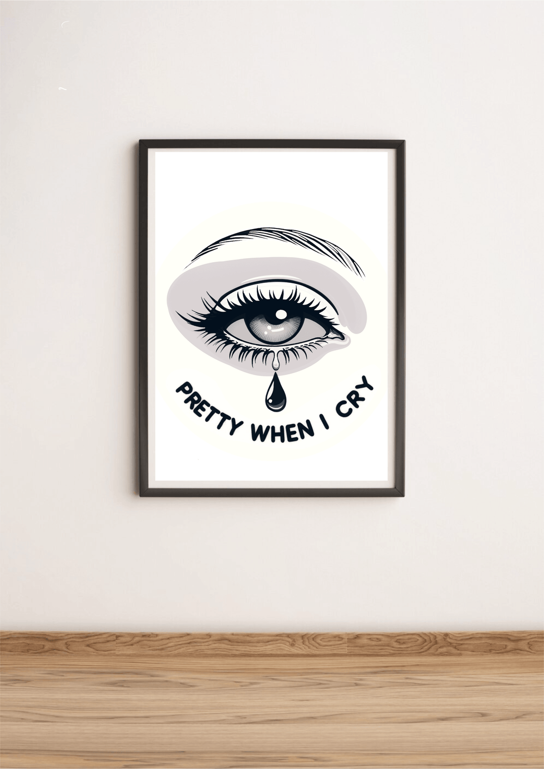 Introducing the "Pretty When I Cry" print—an eye-catching piece of art that brings a pop of emotion to any space! Featuring a beautifully illustrated crying eye with fluttery long lashes and a striking eyebrow, this print stands out against its backdrop. The phrase "Pretty When I Cry" is artfully displayed in bold, curved letters beneath the teardrop, adding an extra layer of charm. Whether leaning against a white wall or resting on light wooden flooring, this framed artwork is sure to elevate your decor. W