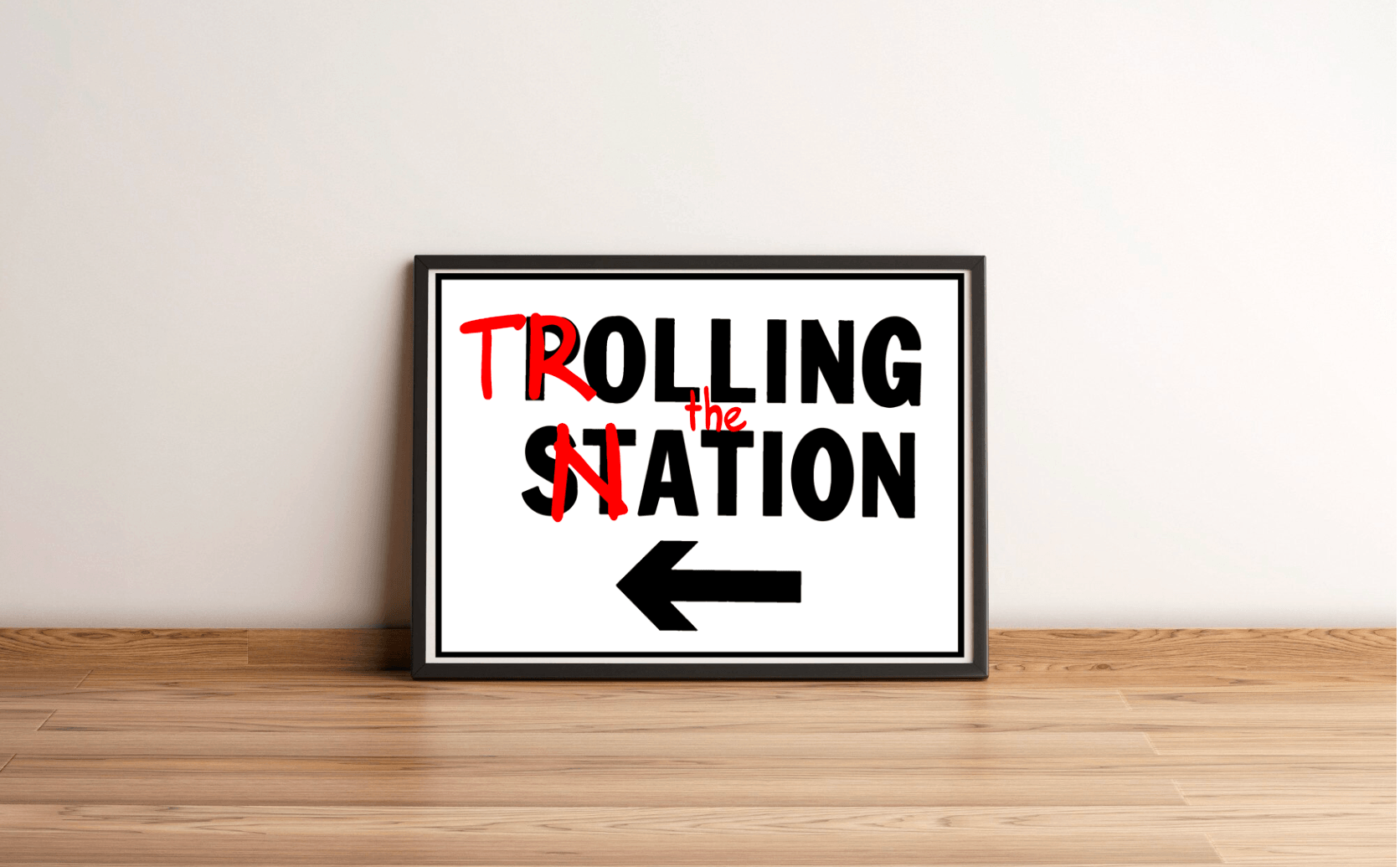 A framed print called "Trolling the Nation" sits playfully on a wooden floor, leaning against a bright white wall. The letters "T" and "N" stand out in bold red, capturing your attention immediately. Just below, an arrow cheekily points to the left, offering a clever mix of socio-political commentary with a dash of satire. This piece is sure to spark conversation and bring a smile!