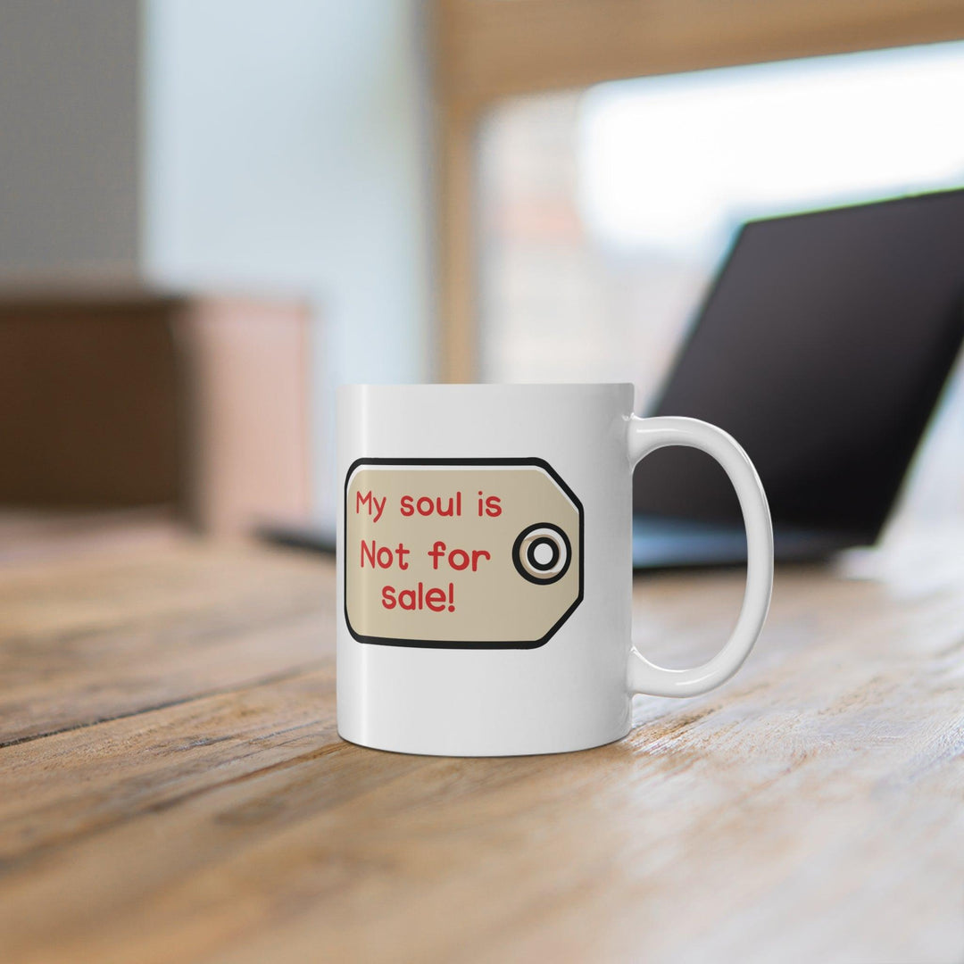 Bold white ceramic mug with a dramatic eye illustration and the text 'My Soul Is Not For Sale,' offering a statement piece for those who value their integrity.