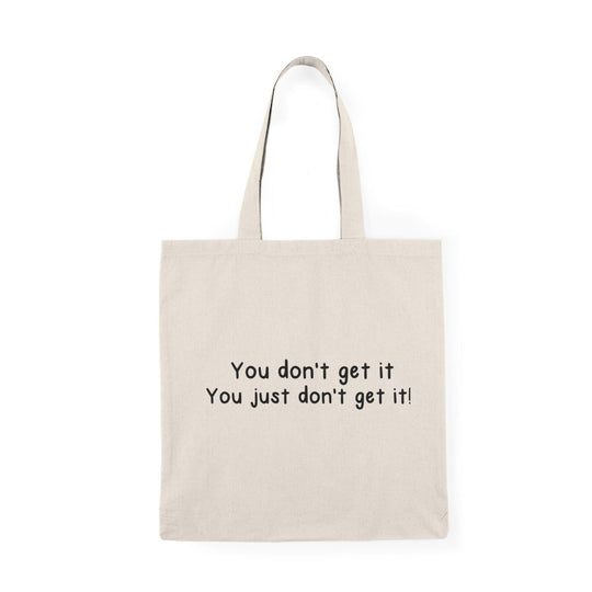 A natural canvas tote bag with a minimalist design featuring the phrase 'You don't get it. You just don't get it!' The straightforward text conveys a sense of frustration in a light-hearted manner, perfect for those who enjoy sarcasm