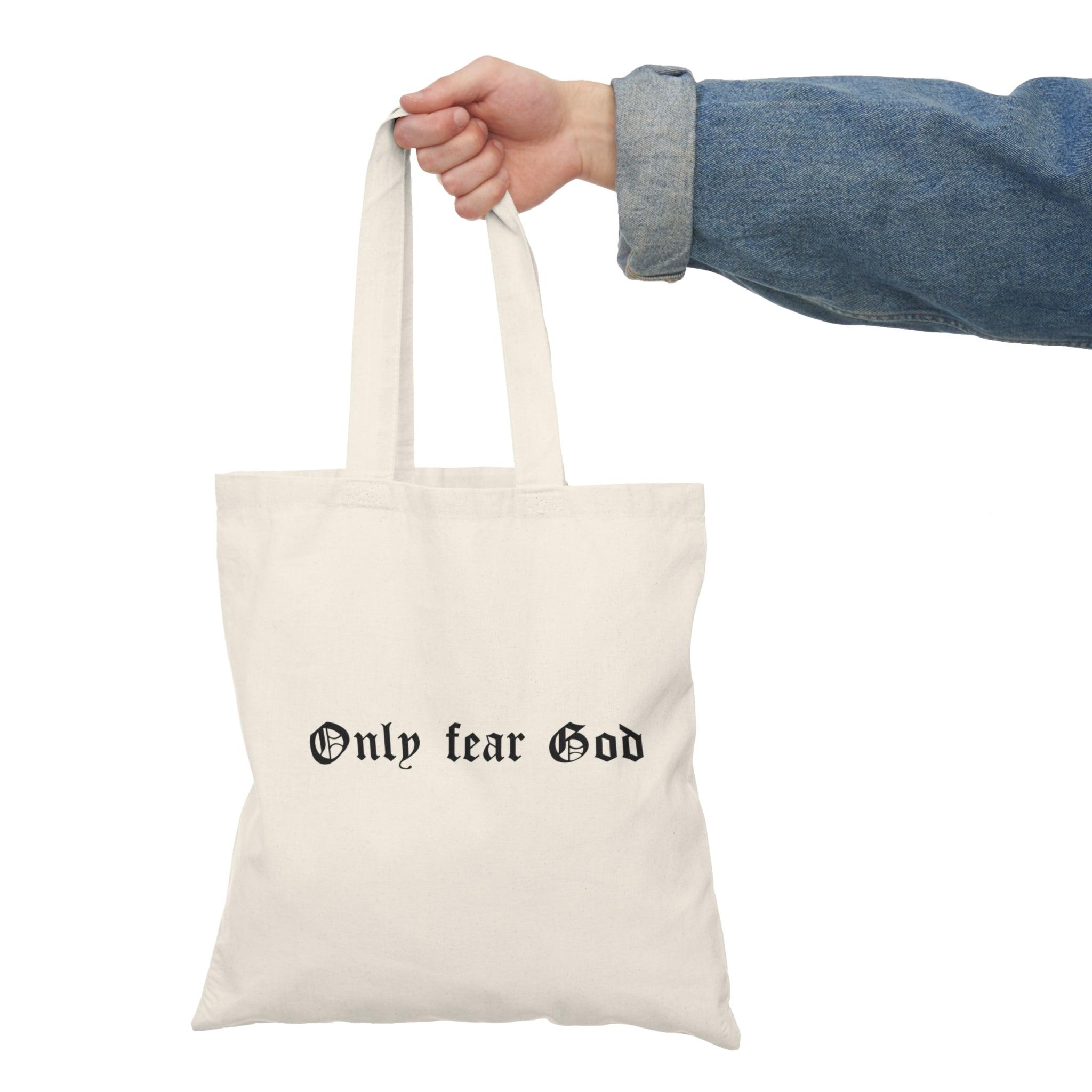 A cream tote bag featuring the bold statement 'Only Fear God' in a striking font. This simple yet powerful design resonates with those who appreciate faith-based messages, making it a meaningful accessory for daily use
