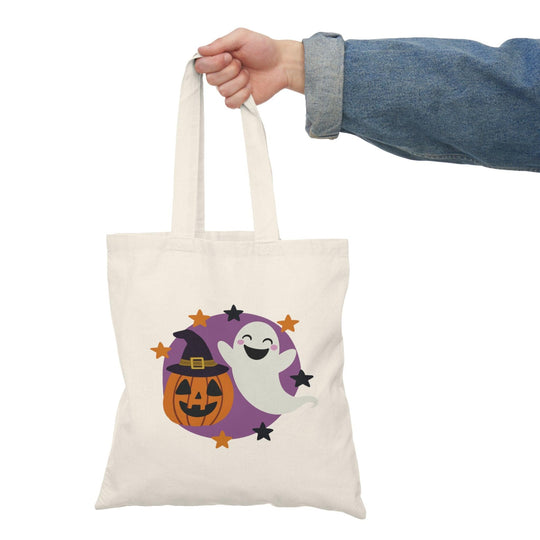 Tote bag featuring a whimsical illustration of a friendly ghost and a carved Halloween pumpkin, both adorned with playful expressions. The colorful design captures the festive spirit of Halloween, making it a perfect accessory for trick-or-treating or adding a fun touch to your everyday style