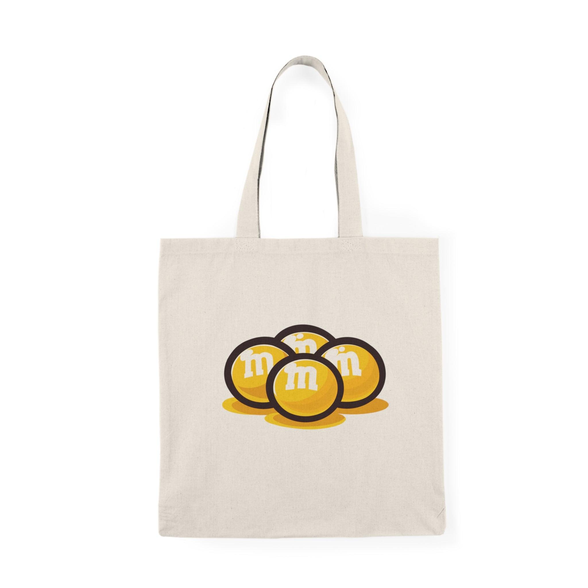 Fun and playful canvas tote bag featuring the classic M&M’s candy logo in bright colors. Perfect for casual outings, shopping trips, or as a gift for candy lovers. Durable and eco-friendly - Baby Keo