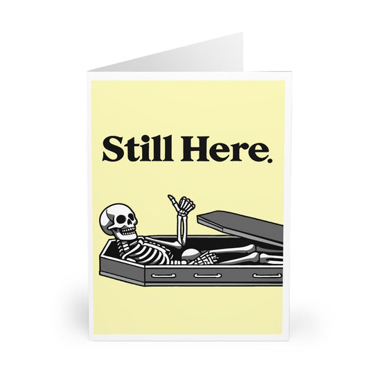 Playful card showing a relaxed skeleton with the phrase 'Still Here.' A cheeky way to send greetings or celebrate resilience - Baby Keo.